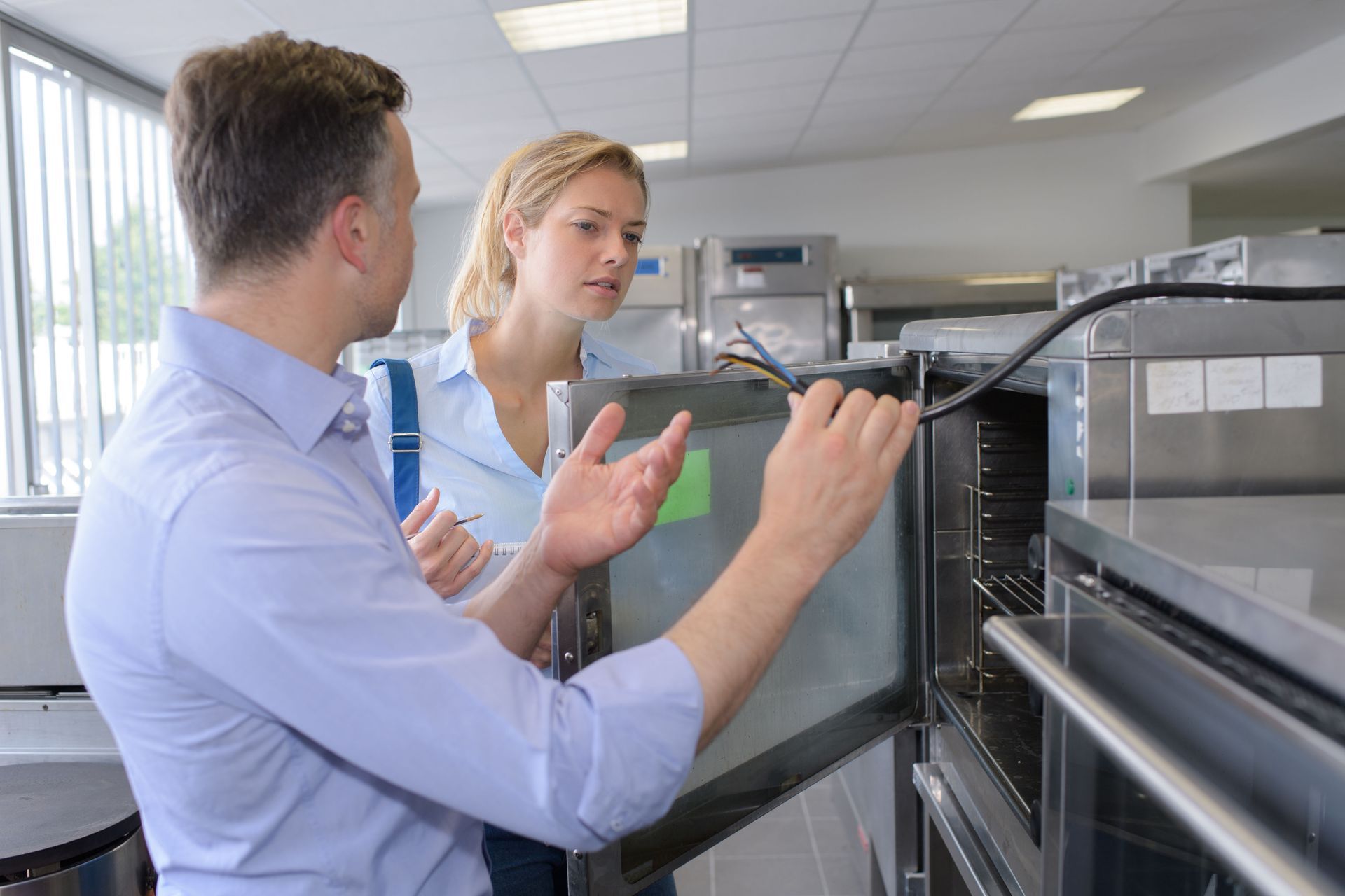 Two people discussing machinery in a bright industrial lab