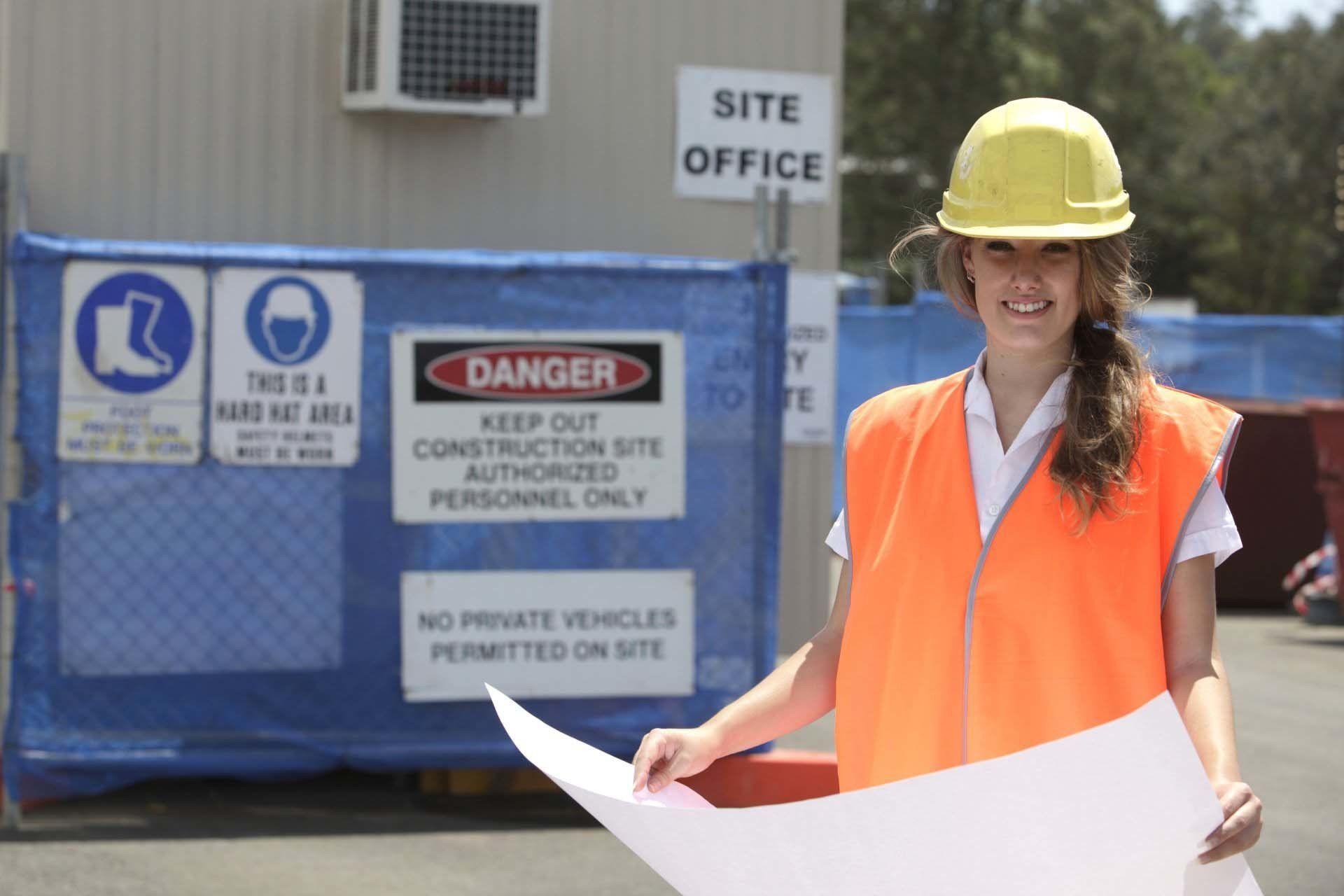 A woman is standing in front of a sign that says danger