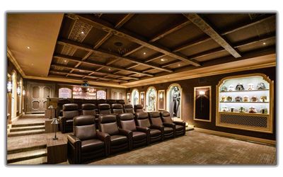 A home theater with brown leather rows of seating, recessed lighting, a coffered ceiling, and a lighted display case.