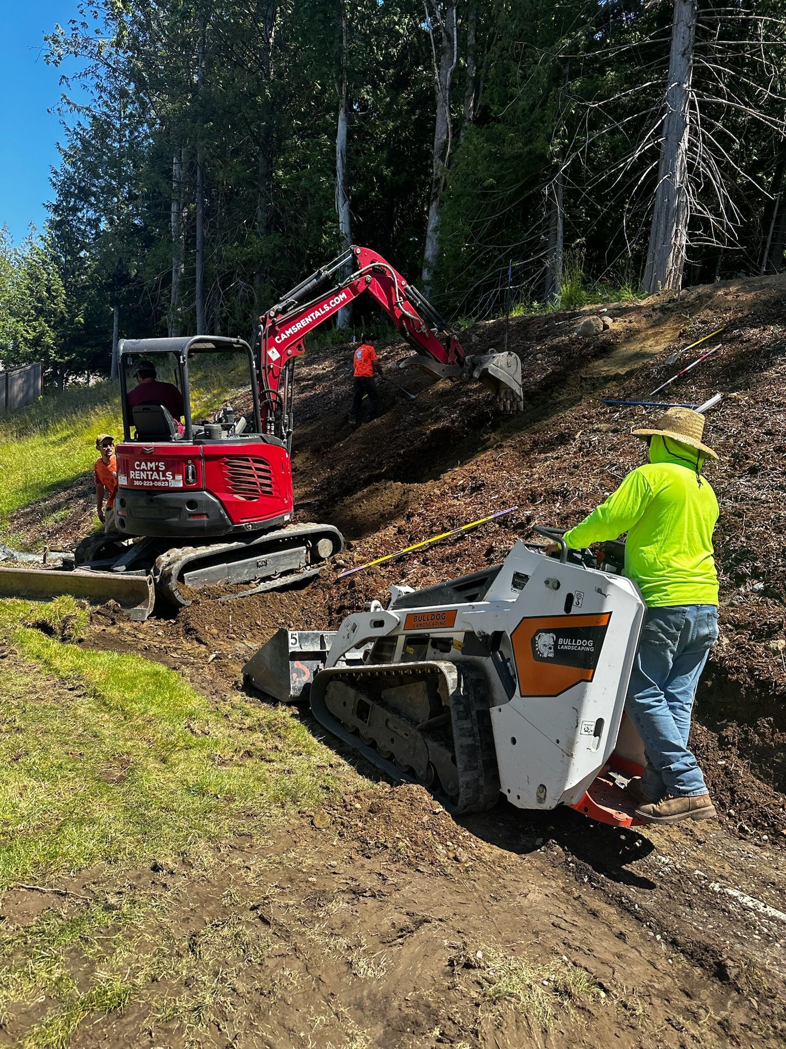A man is standing next to a bulldozer on a dirt road.