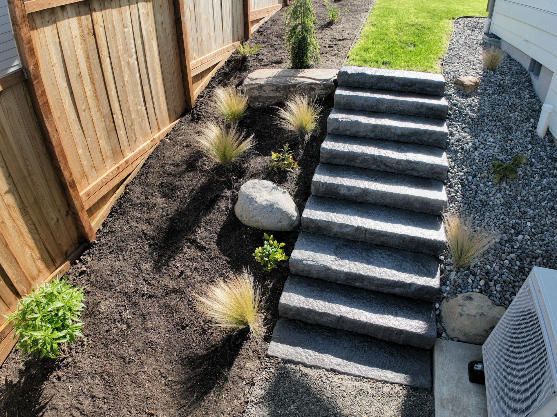 A set of stairs leading up to a house with a wooden fence in the background.