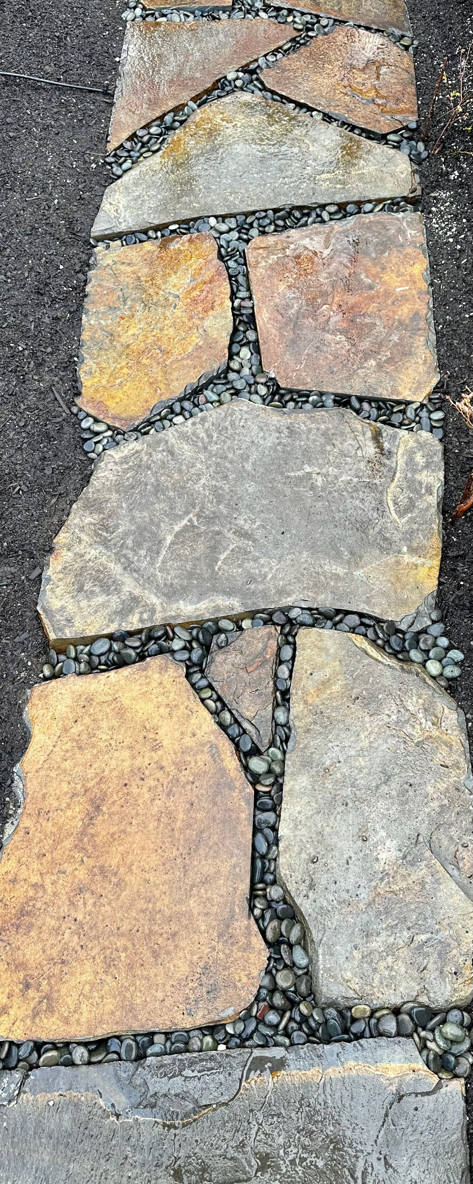 A close up of a stone walkway on the side of a road.