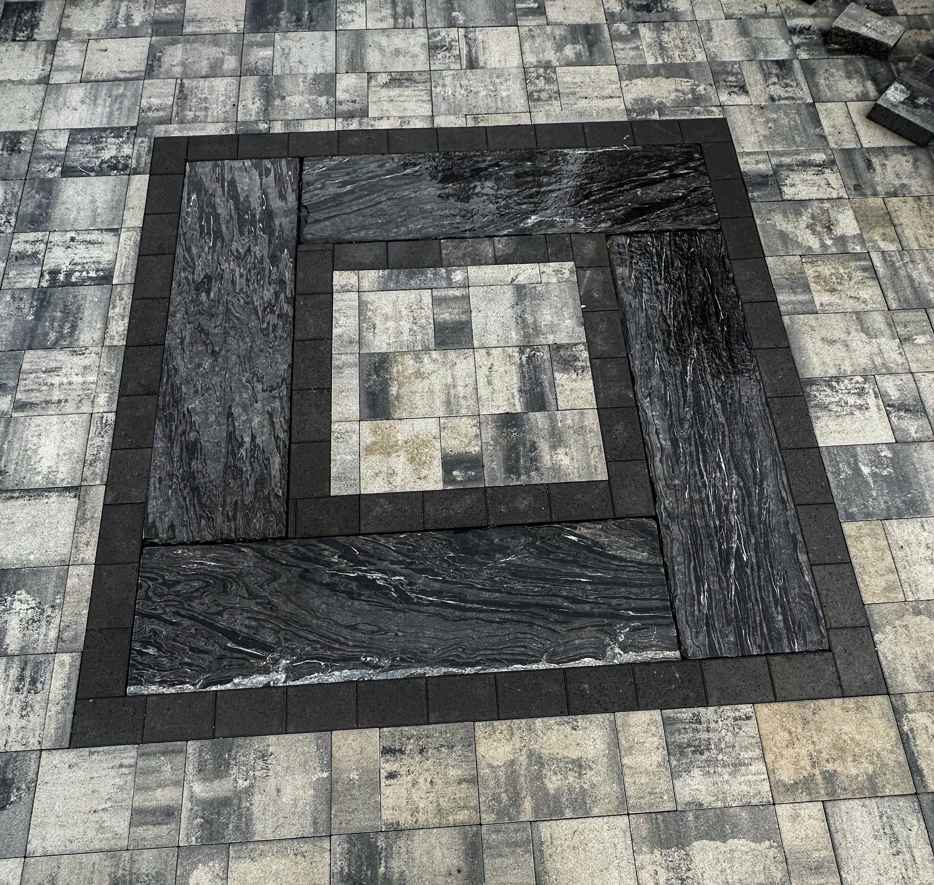A black and white square on a brick floor