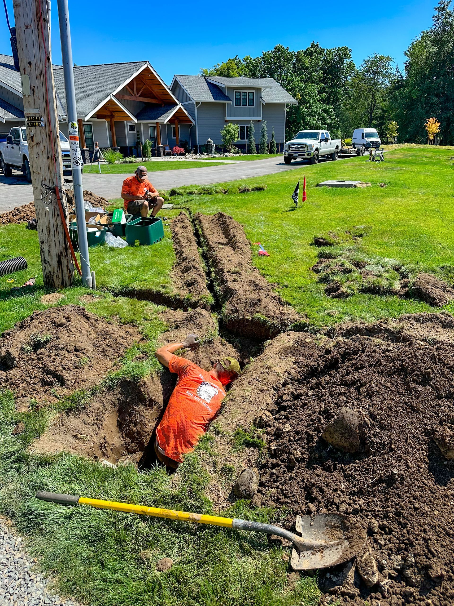 A man is laying in the dirt next to a shovel.