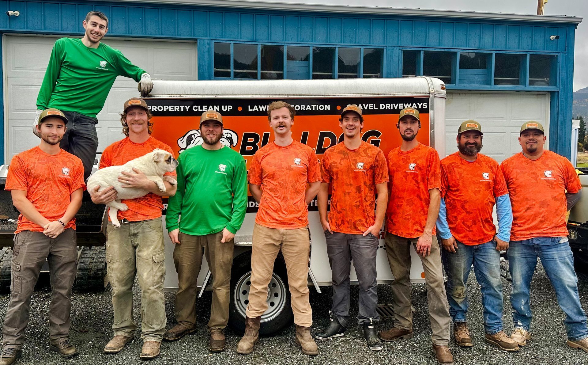 A group of men are posing for a picture in front of a building