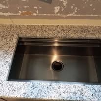 A stainless steel sink is sitting on top of a granite counter top.