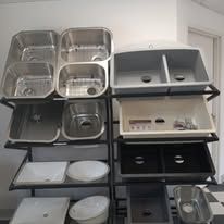 A display of stainless steel sinks in a store.