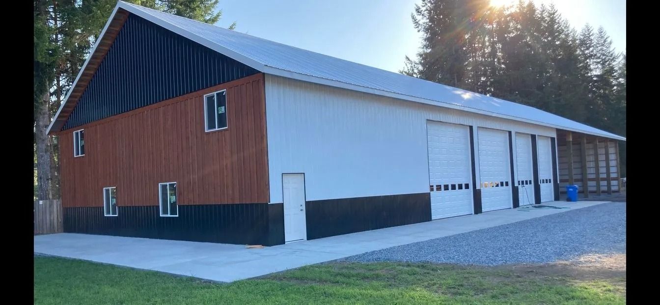A large two-story building with a brown and white exterior, garage doors, and a metal roof.