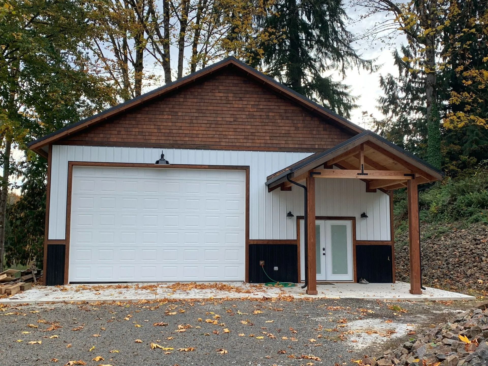 White and brown garage building with a small covered porch.
