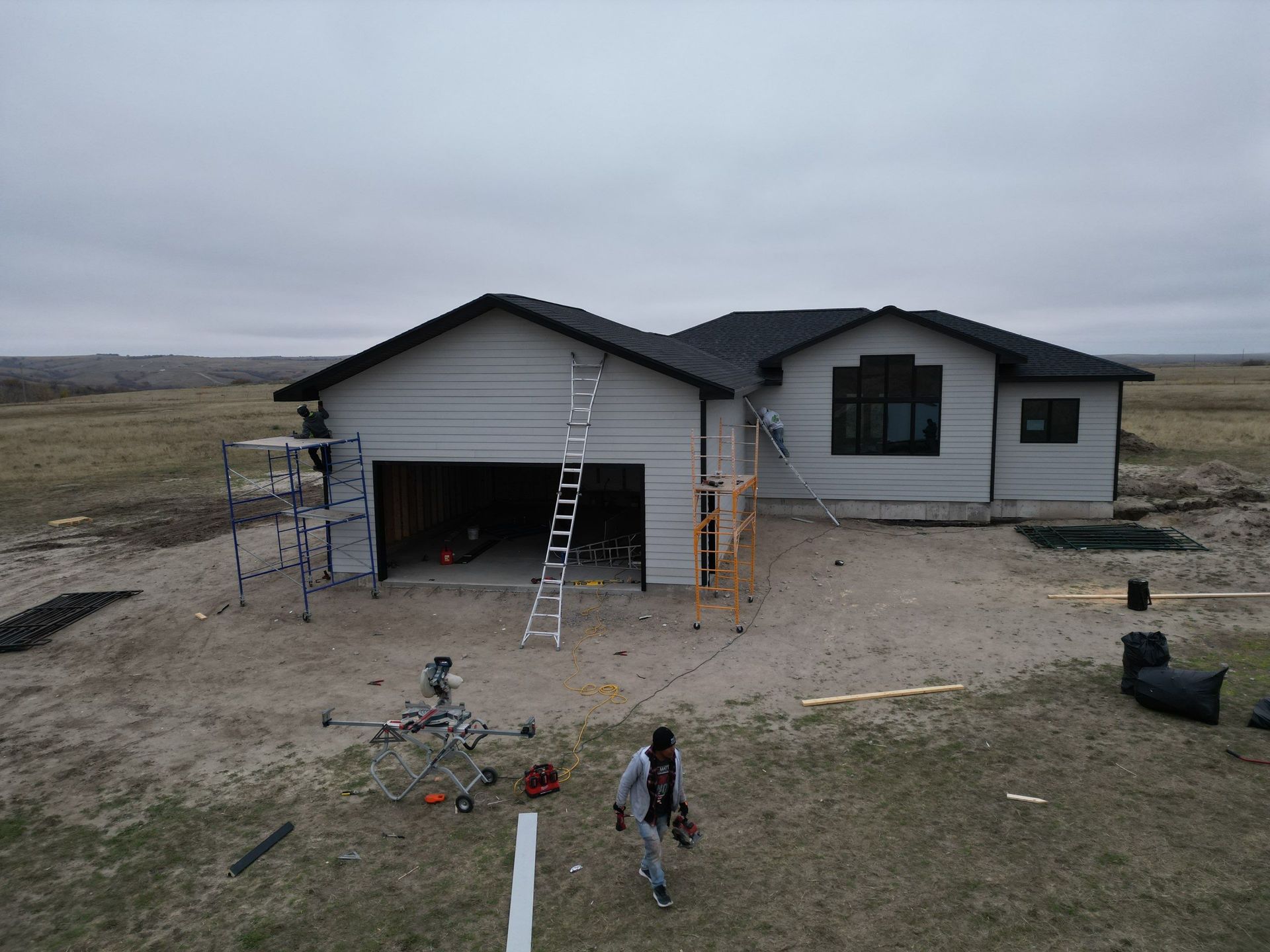 A man is standing in front of a house under construction.