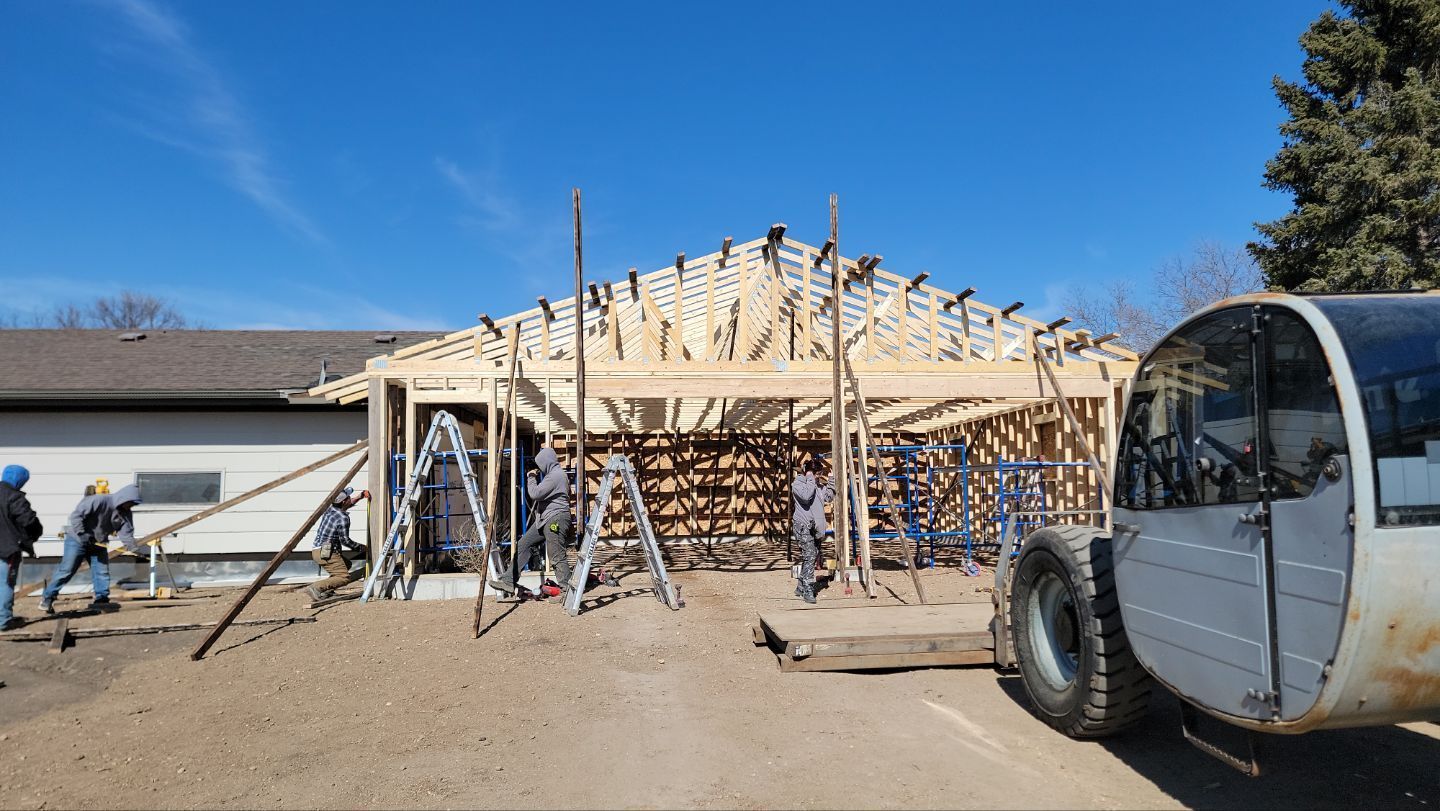 A white van is parked in front of a house under construction.