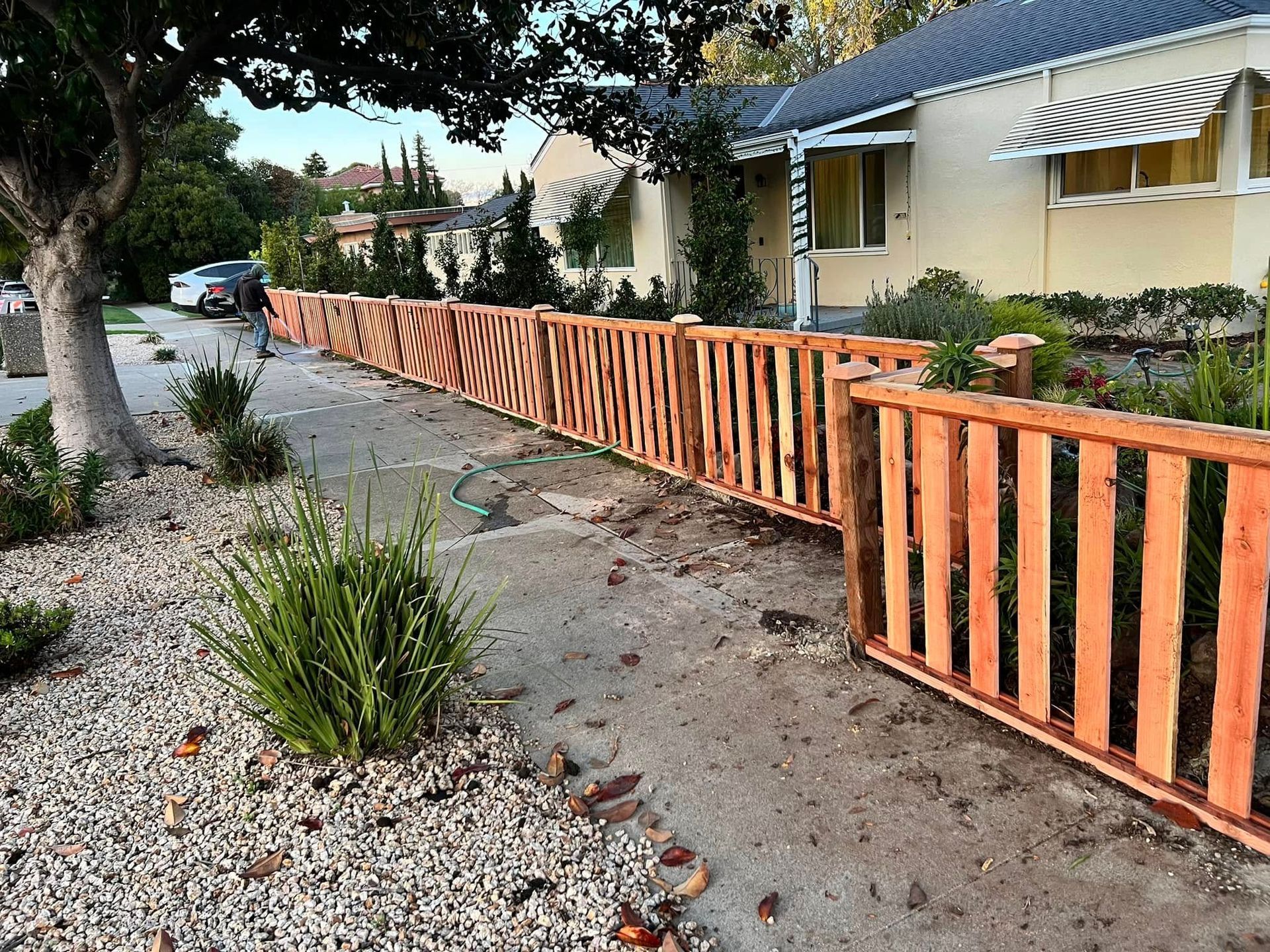 A wooden fence is sitting in front of a house.