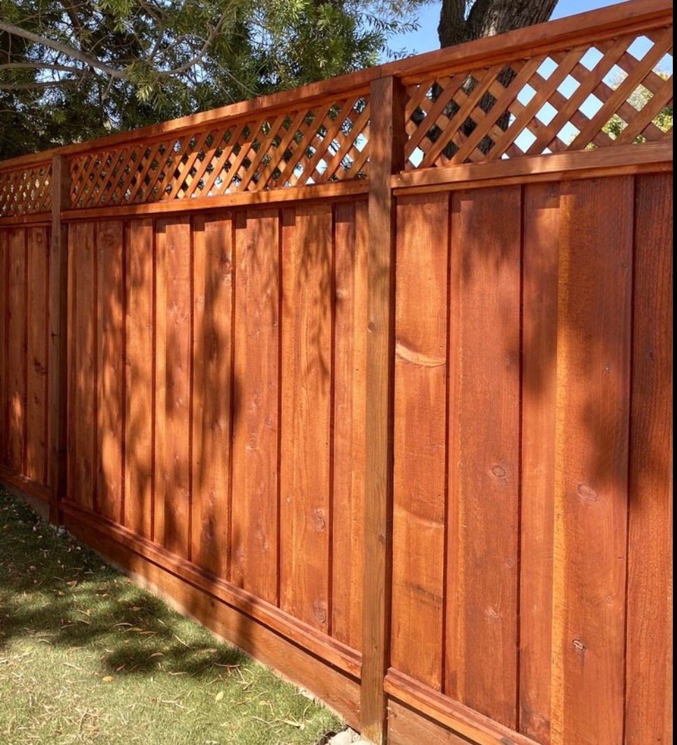 A close up of a wooden fence with a lattice top.
