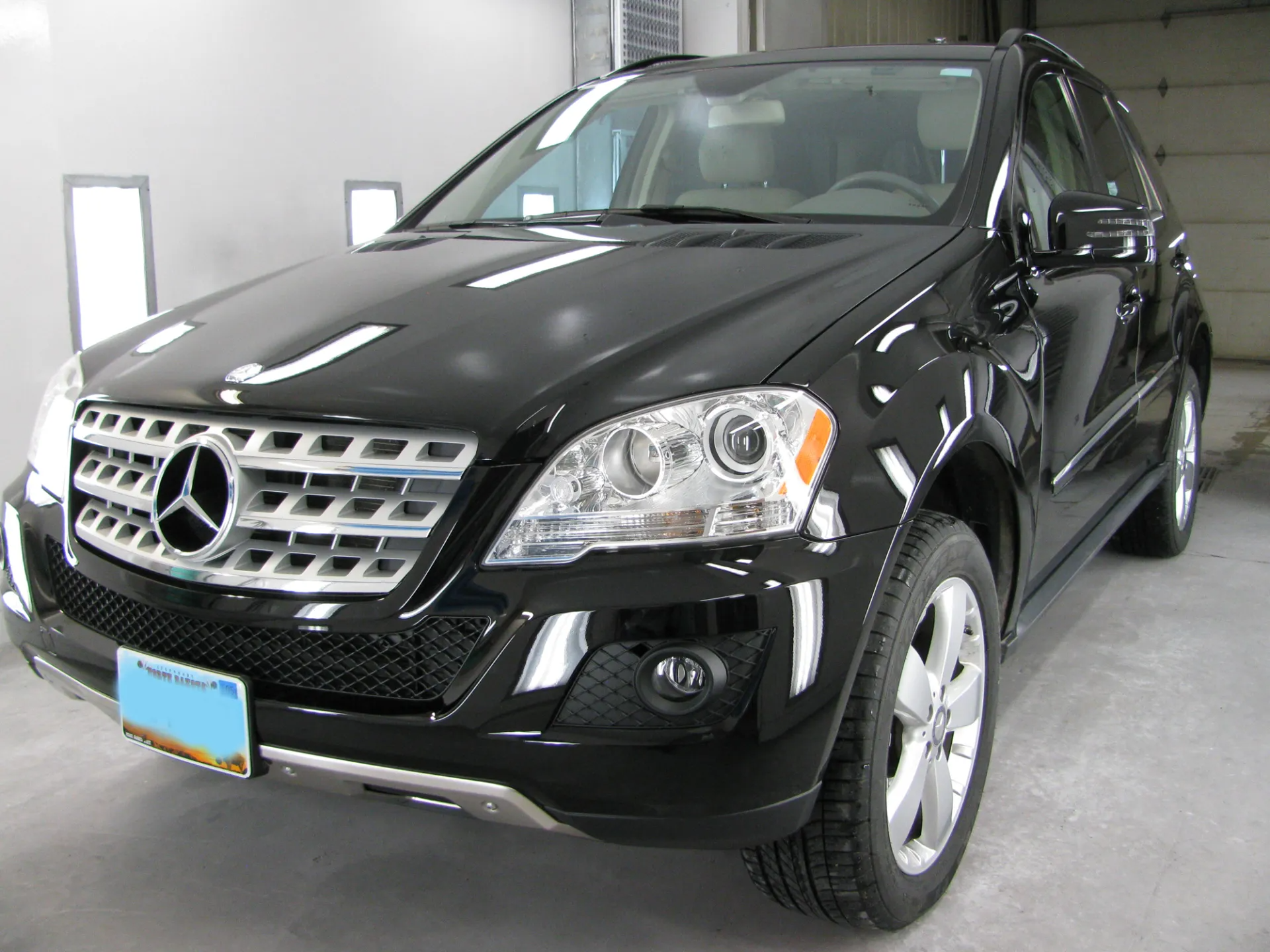 Black Mercedes-Benz SUV parked in a garage with a light-colored floor and walls.