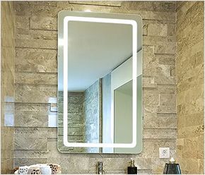 A bathroom mirror with a light on it is hanging on a brick wall.