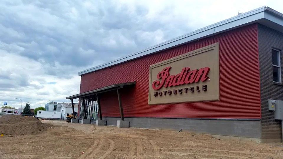 Indian motorcycle dealership building with red siding and a cloudy sky