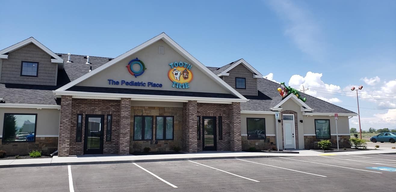 The PokéMans restaurant storefront with stone façade and parking lot under a blue sky