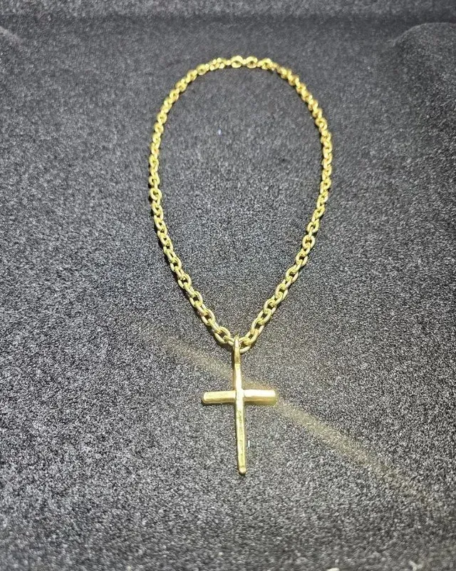 A gold chain with a cross pendant on it
