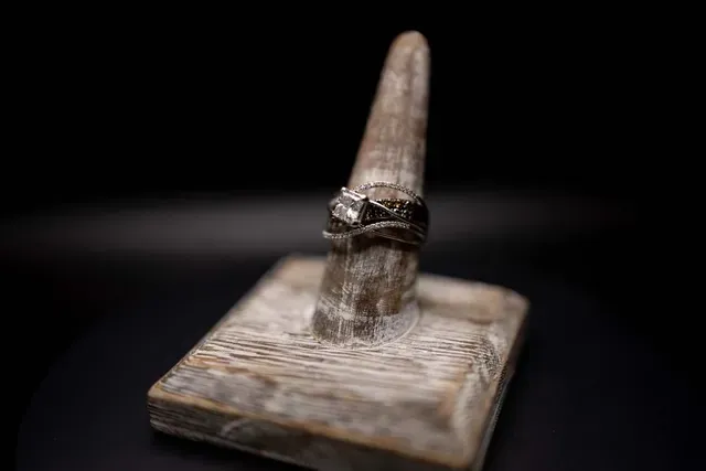 A ring is sitting on top of a wooden ring holder.