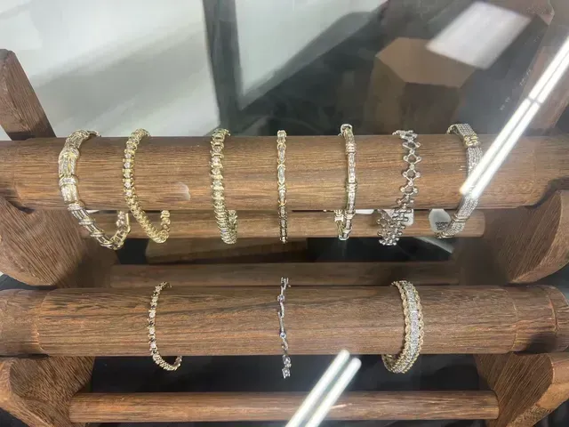 Several bracelets are displayed on a wooden stand