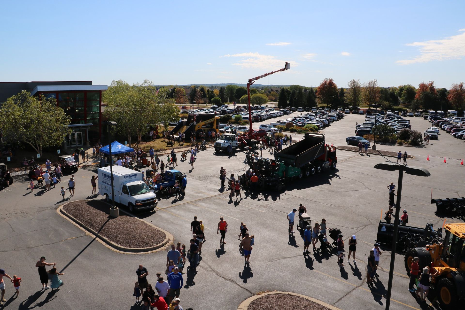An aerial view of a parking lot filled with cars and people