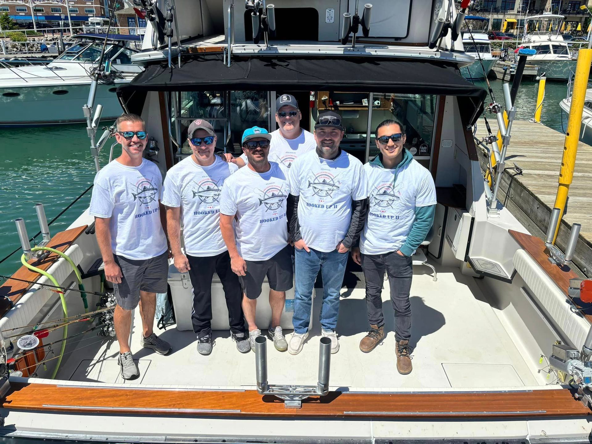 A group of men are posing for a picture on the back of a boat.