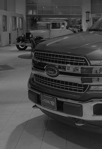 a black and white photo of a Ford truck in a showroom