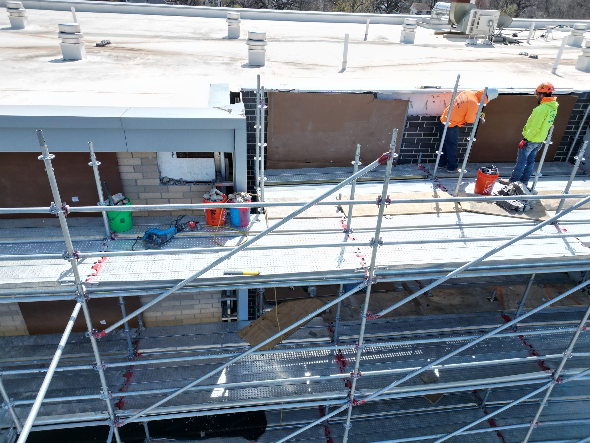Construction debris on a concrete surface with a mop and other tools.
