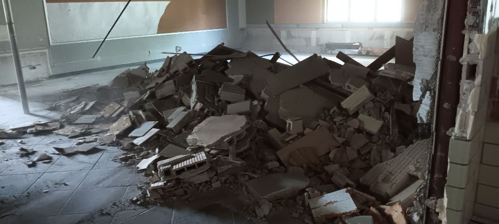 A pile of rubble inside a building. Dusty environment with a window in the background.