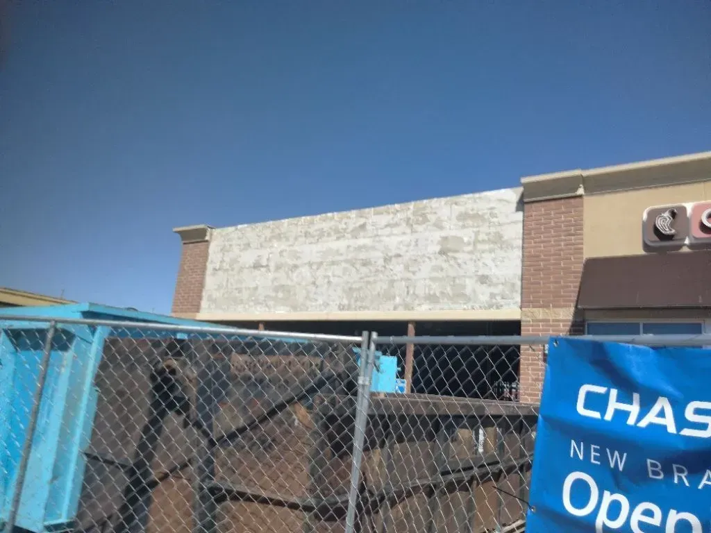 Building under construction; signage for Chase bank with blue sky.