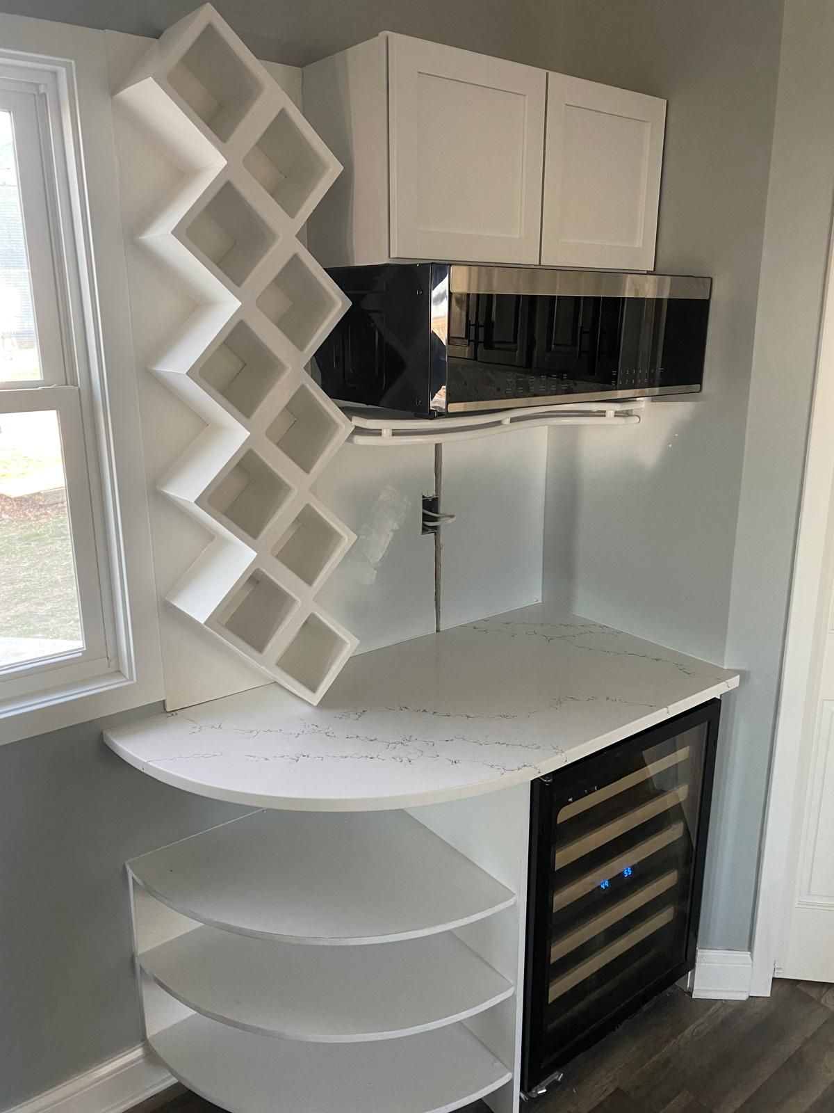 A kitchen with a wine cooler and a wine rack.