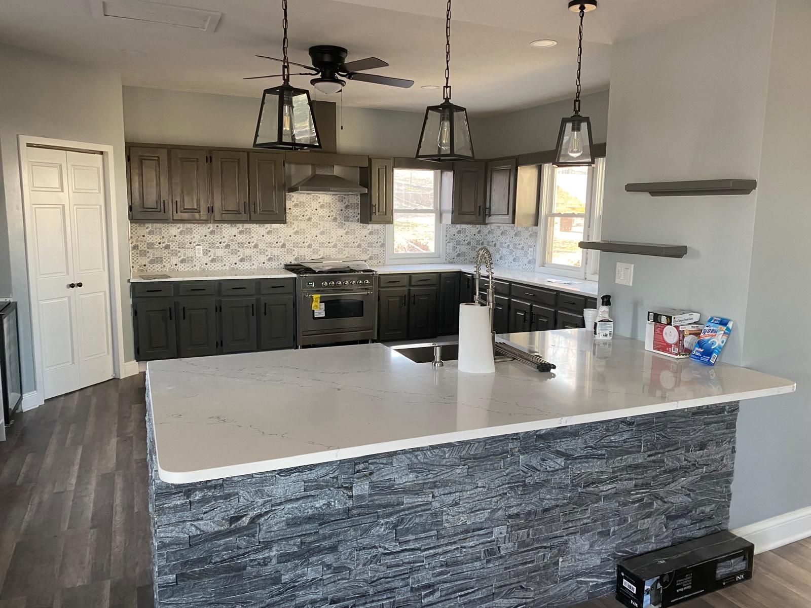 A kitchen with a large island and a ceiling fan.