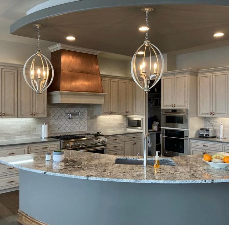 A kitchen with a large island and a copper hood
