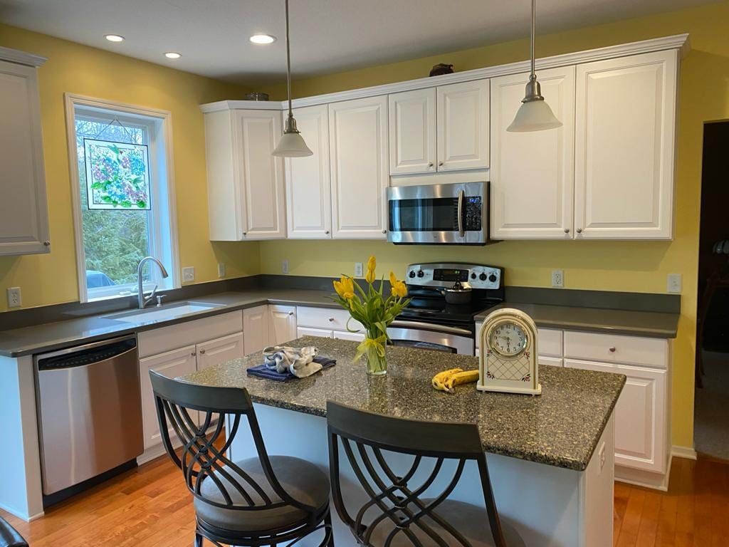 A kitchen with white cabinets and granite counter tops
