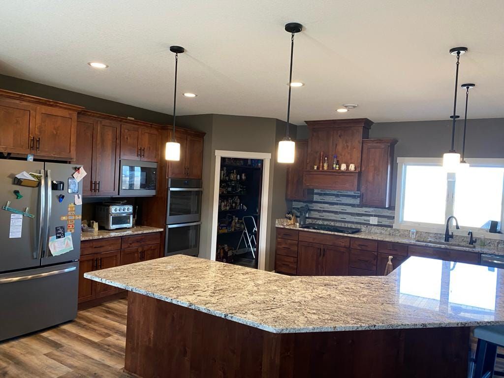 A kitchen with stainless steel appliances , granite counter tops , and wooden cabinets.