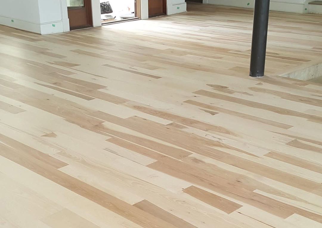 A wooden floor is being installed in a room.