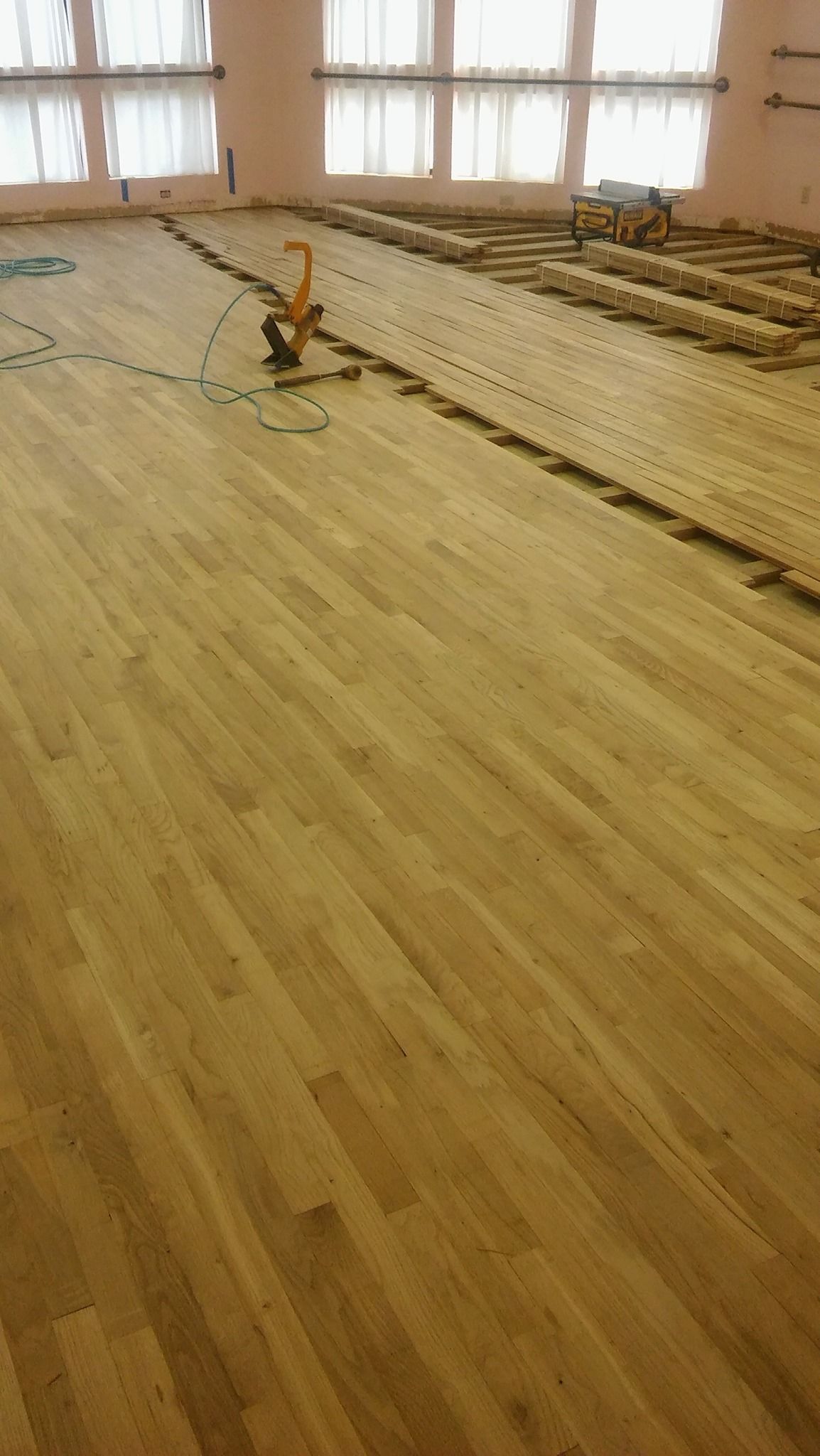 A large wooden floor is being installed in a room.