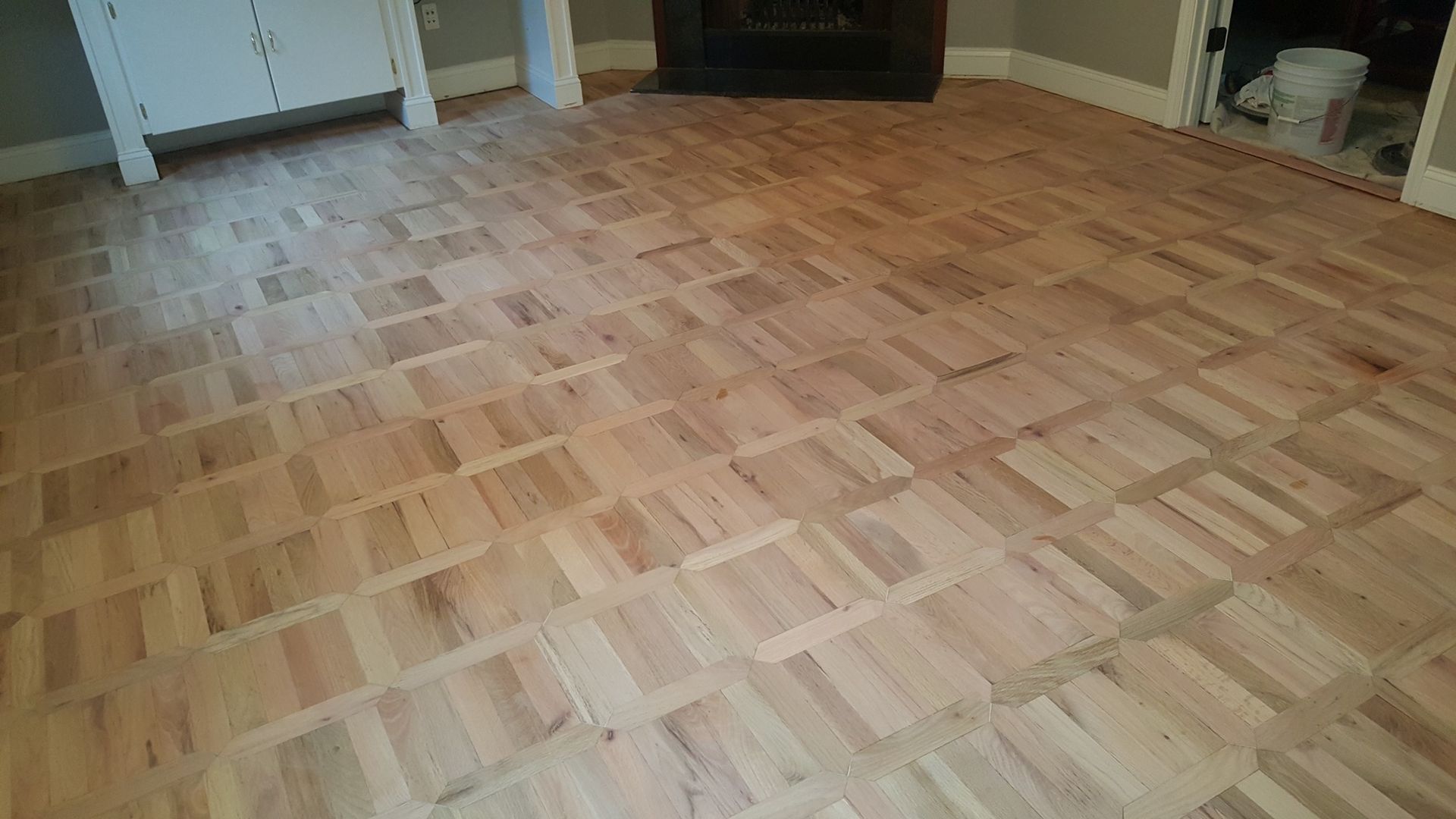 A living room with a wooden floor and a fireplace.