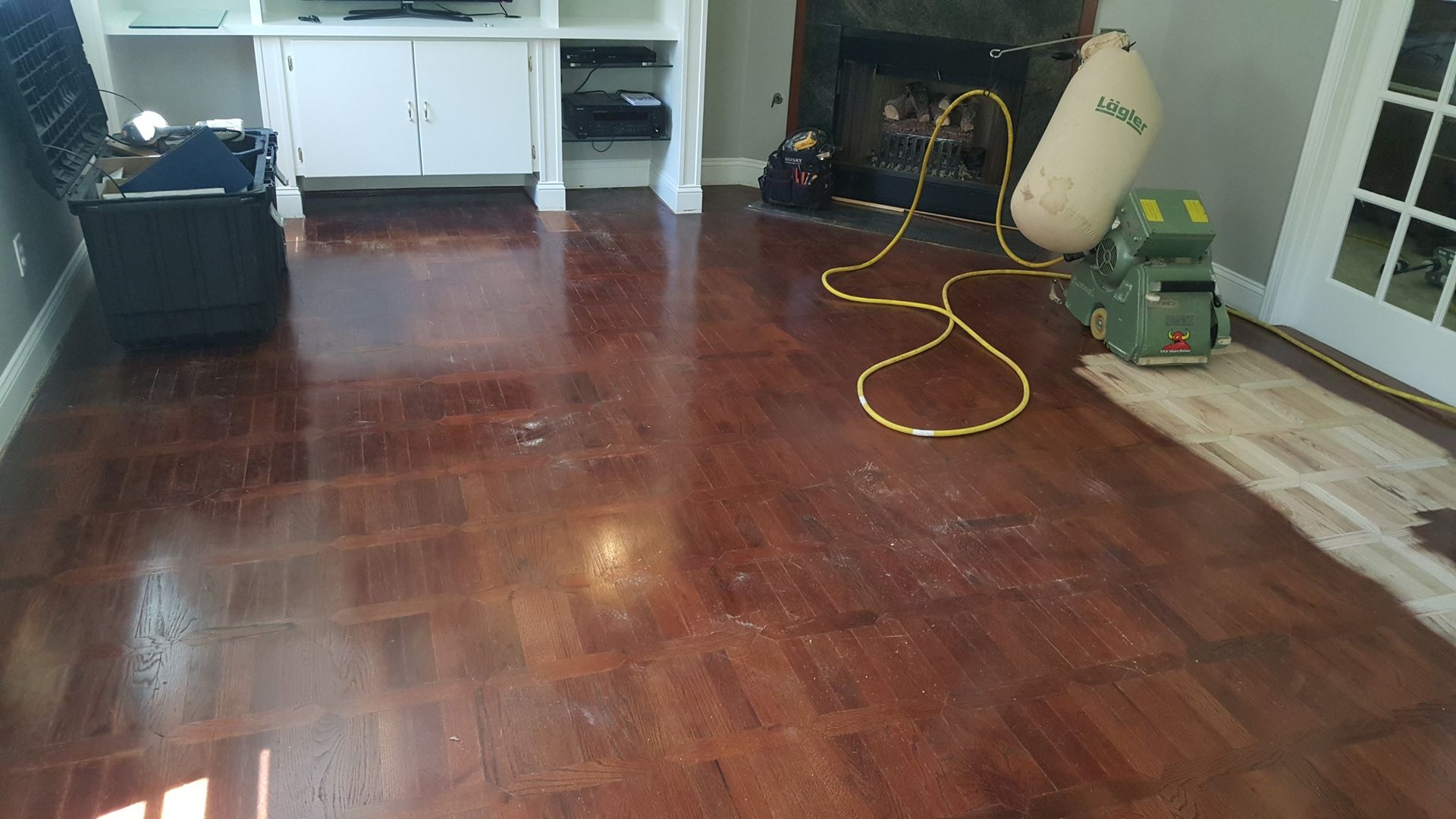 A living room with hardwood floors and a vacuum cleaner on the floor.