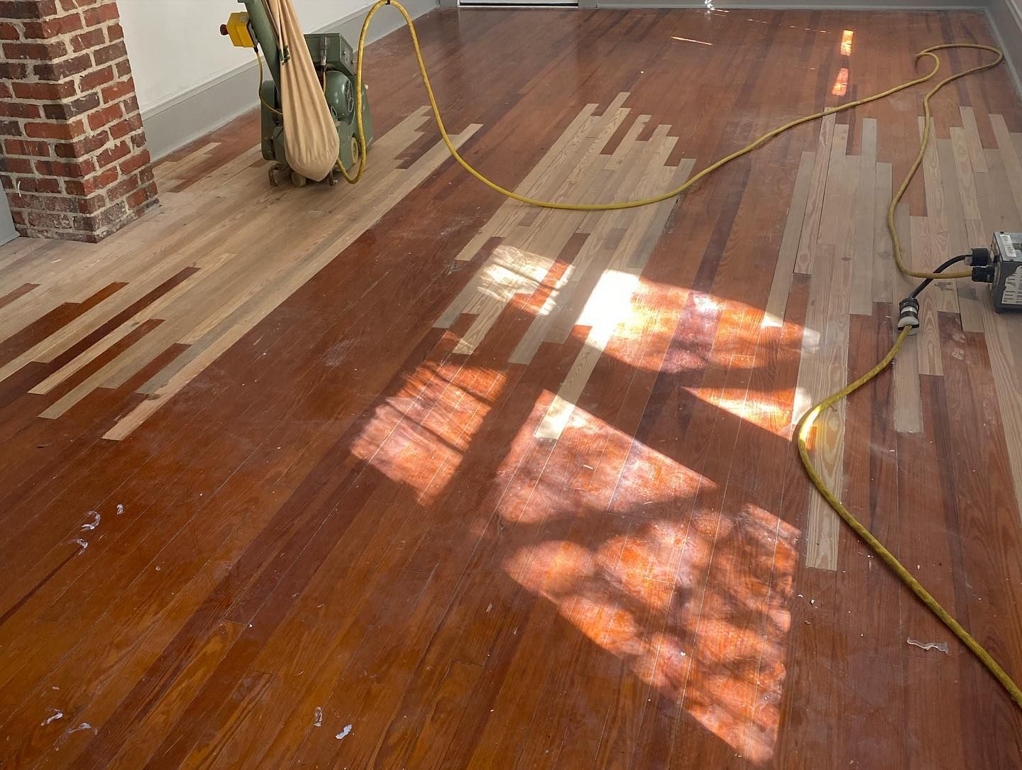 A wooden floor with a brick chimney in the background.