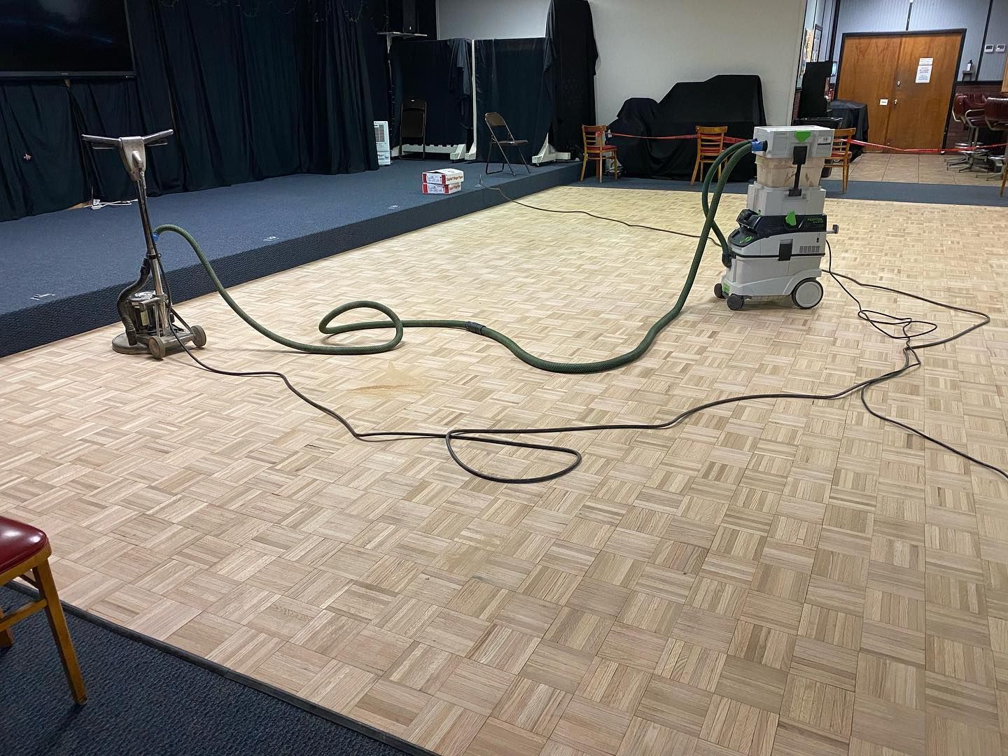 A vacuum cleaner is sitting on a wooden floor in a room.