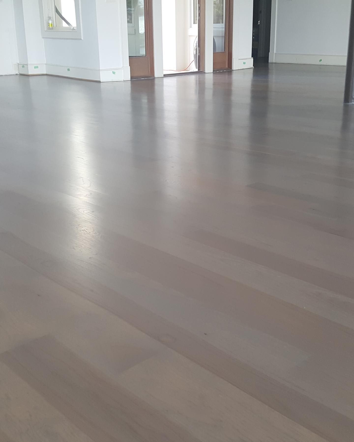 A large room with a wooden floor and white walls.