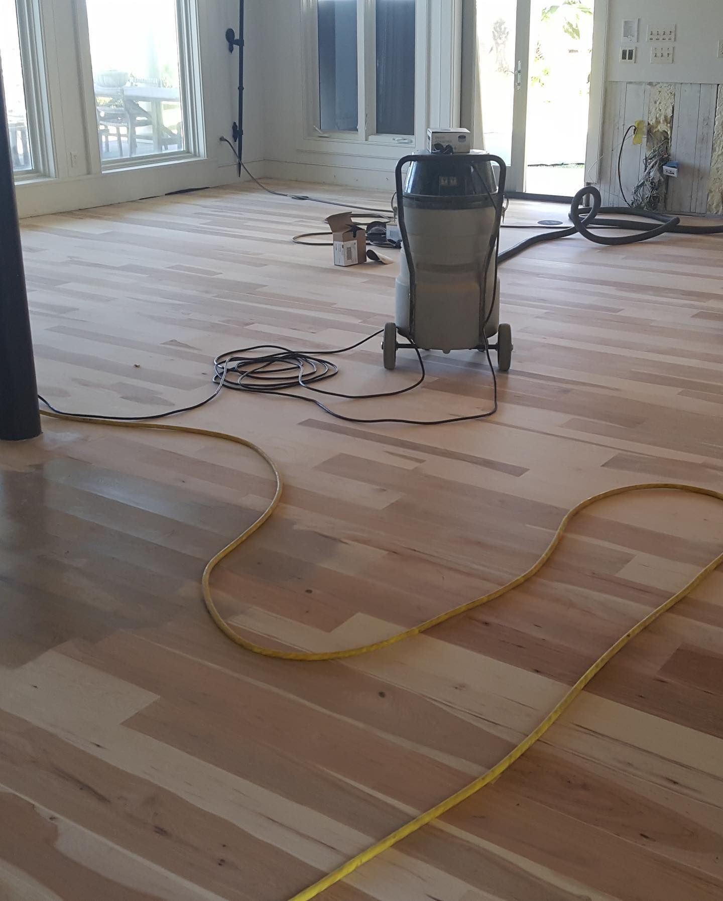 A vacuum cleaner is sitting on a wooden floor.