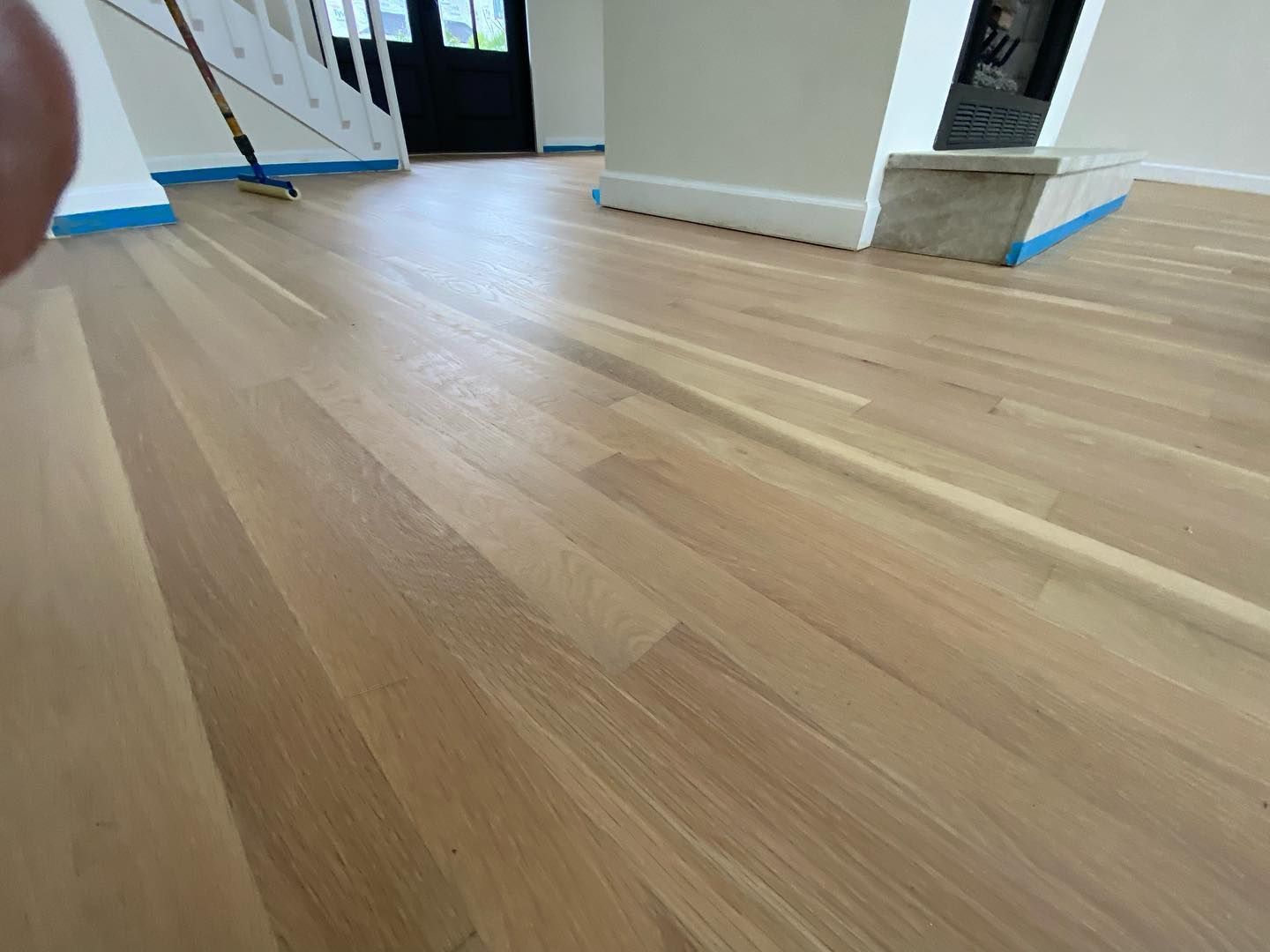 A person is standing on a wooden floor in a room.