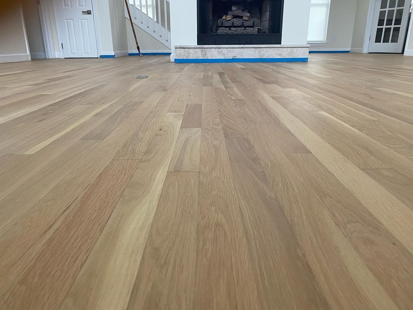 A living room with hardwood floors and a fireplace.