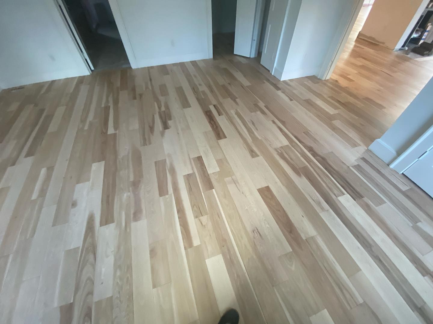 A person is standing on a wooden floor in a room.