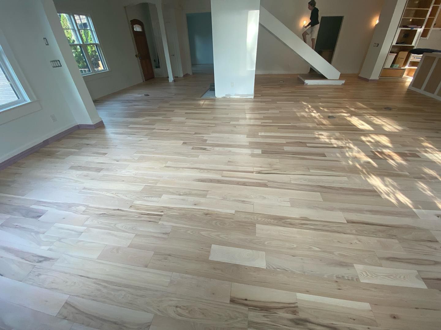 A large room with a wooden floor and stairs.