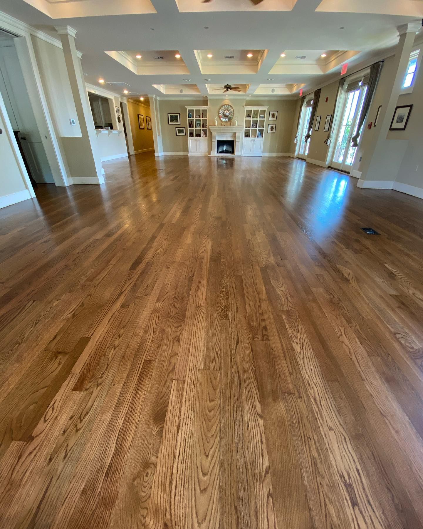 A large room with hardwood floors and a fireplace.