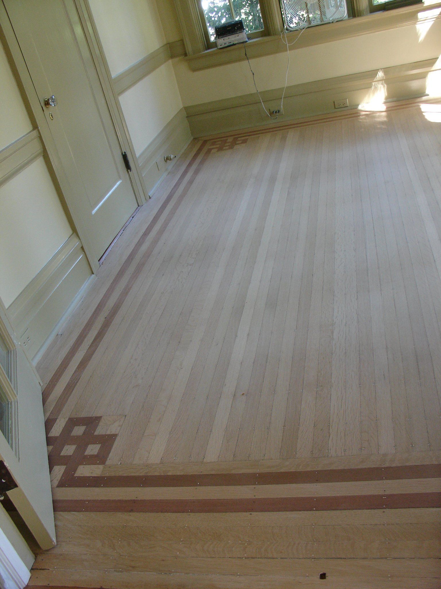 A room with a wooden floor and stairs.