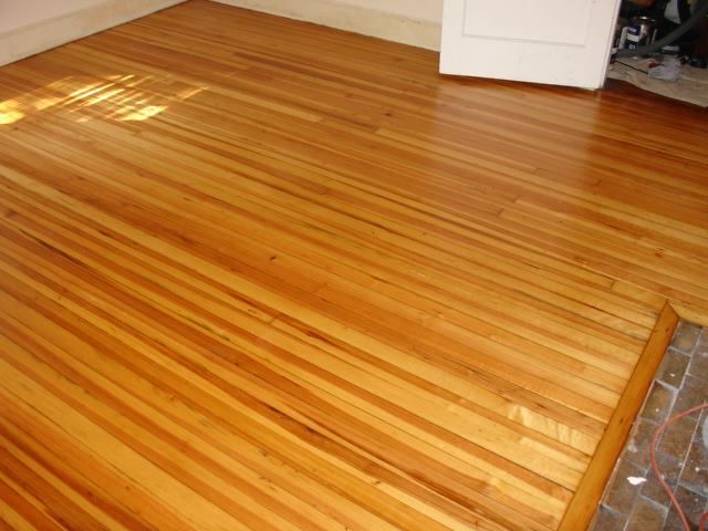 A wooden floor in a room with a white door.